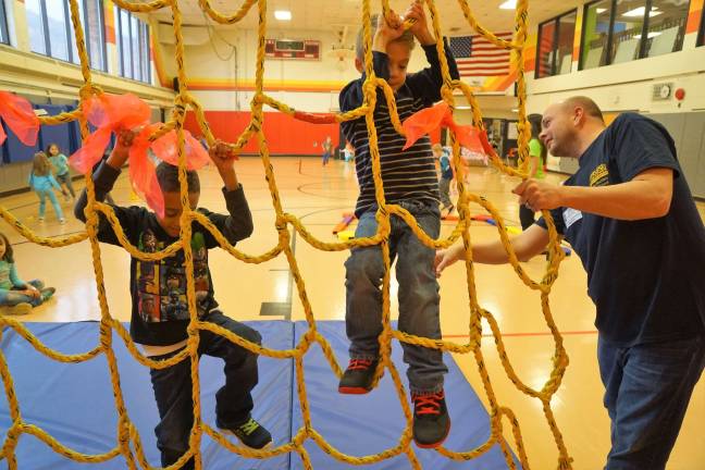 Cedar Mountain 'jumps rope for heart' Dedicated Dad Patrick Curreri, on right, helps students climb the rope net.
