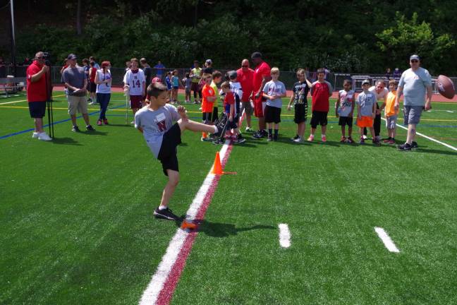Children gather to punt, pass and kick Ten-year-old Michael Meilillo kicks the ball in the kick contest. Meilillo plays football for the Kittatinny Cougars.