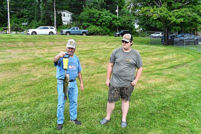 Photos: Wantage fishing contest <b>Warren Wisse, left, president of the Wantage Recreation Committee, measures a bass caught by Kevin Schmitz of Wantage.</b>