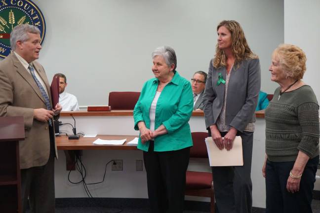 Freeholder George Graham, left, presents a proclamation recognizing May as older Americans month. Seen at right are Joan Shaw, Sarah Balzano and Eileen Francis.