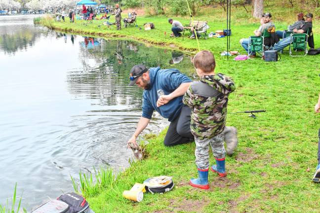 Photos: 63rd annual Small Fry Trout Fishing Contest A man reaches in the water to pull up a fish Saturday, April 26 at the 63rd annual Small Fry Trout Fishing Contest at Sussex County Community College in Newton. (Photos by Maria Kovic)