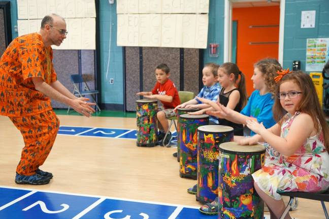 On left, music teacher Michael Moschella inspires students as they play the Djembe Drums.