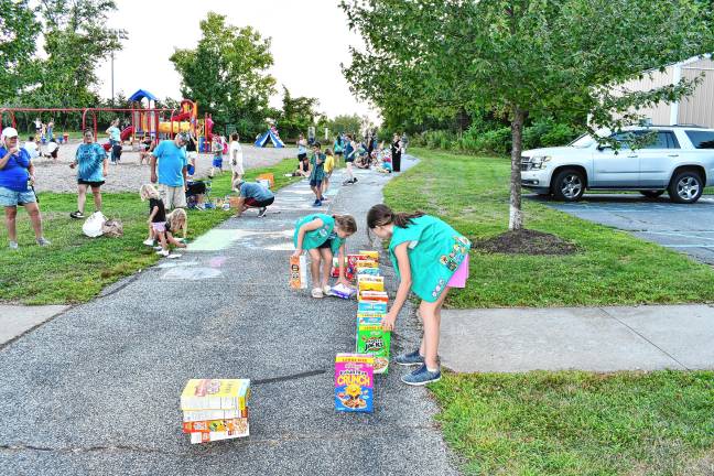 Photos: Sidewalk Chalk Art Festival in Vernon <b>Girl Scouts line up cereal boxes for a domino line.</b>