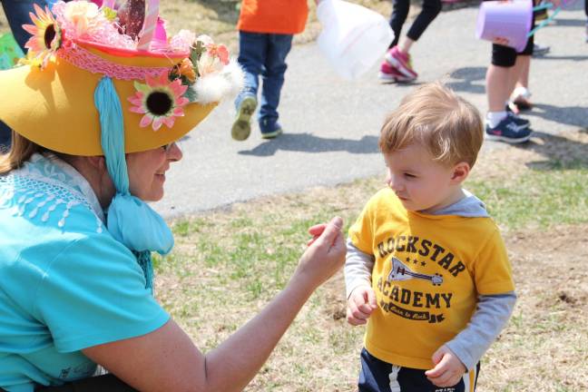 DAR hosts Easter egg hunt Collin Lewis of Wantage debates giving a high five to stranger Maureen McCarty with the Easter bonnet on.