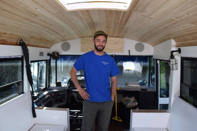 Photo by Erika Norton Michael Fuehrer stands inside his &quot;skoolie,&quot; a bus that has been converted into a tiny home.