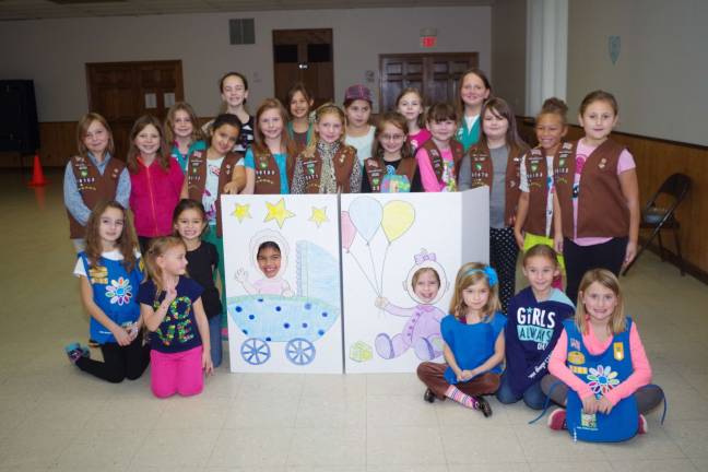 Local girl scouts donate to Birth Haven The girls assembled for a group photo with Faith Kliemisch, 6, and Stephanie Smith, 8, smiling through the cutouts.