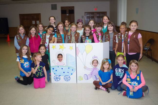 The girls assembled for a group photo with Faith Kliemisch, 6, and Stephanie Smith, 8, smiling through the cutouts.