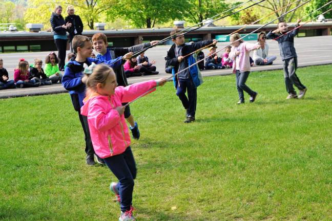 First-graders have fun with the May Pole Dance while Kindergartners watch.