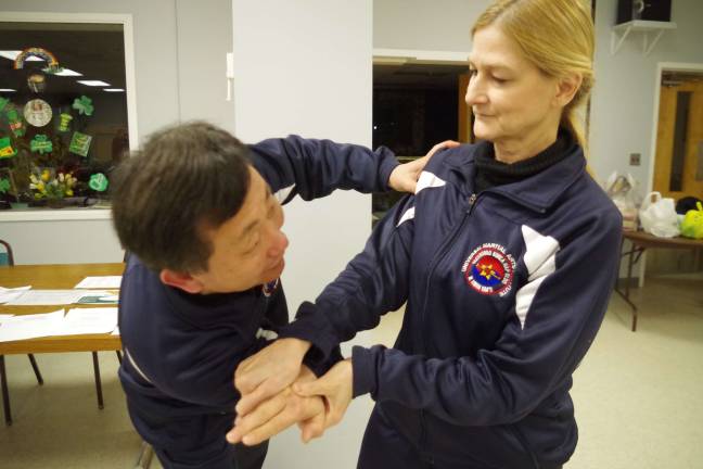 Branchville resident Carole Lynn Servideo is shown executing a series of Hapkido hand techniques with Grandmaster Ik Hwan Kim of Kim&#xed;s Universal Martial Arts Institute in Lafayette.