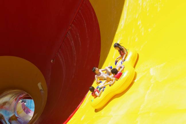 Action Park visitors are shown about to disappear into the narrowing cone of High Anxiety, clearly the most colorful of the park's many rides and attractions.