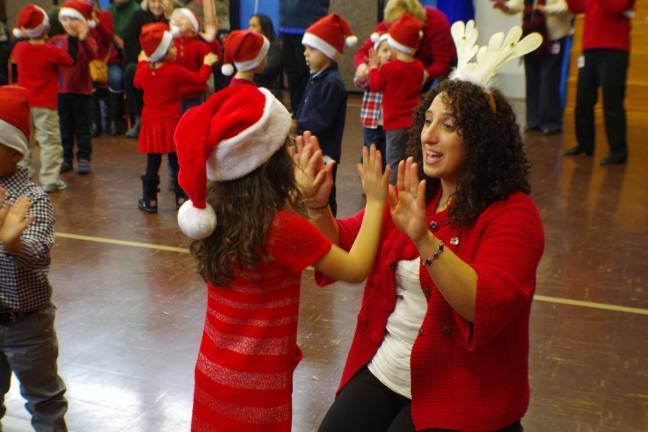 Preschoolers learn through music, movement Photo by Chris Wyman Wearing antlers is preschool teacher Lesley Falgiano as she works with a young student during the Walnut Ridge Primary School preschool students sing along.