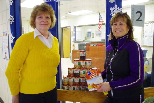 Harvest House secretary and former Glen Meadow teacher Peggy Behnke (left) stands with Glen Meadow physical education teacher Michelle Gagg with food that was collected to benefit local food pantries.