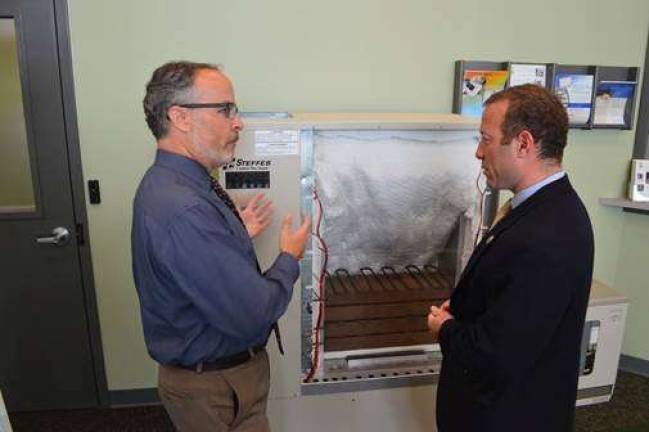 Congressman Josh Gottheimer and Chris Reese, the President &amp; CEO of SREC, examine an electric furnace.