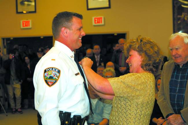 Vernon swears in 4th police chief in township history Photo by Mike Zummo Brian Jernick's lieutenant badge is pinned onto his chest by his wife Nancy at the Nov. 14 Vernon Township Council meeting.