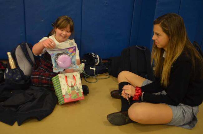 Reverend George A. Brown Memorial School third grade student Kaelynn Muli reacts after receiving a Christmas gift from Pope John XXIII Regional High School freshman Olivia Ingoglia during a Linking Lions meeting in December at Reverend George A. Brown Memorial School in Sparta.