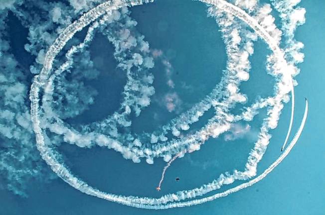 New Jersey Airshow AIR3 Rob Holland, one of the airshow pilots, performs ‘Circle the Jumpers’ where he circles the skydivers with smoke as they jump. (Photo by Ed Bailey)