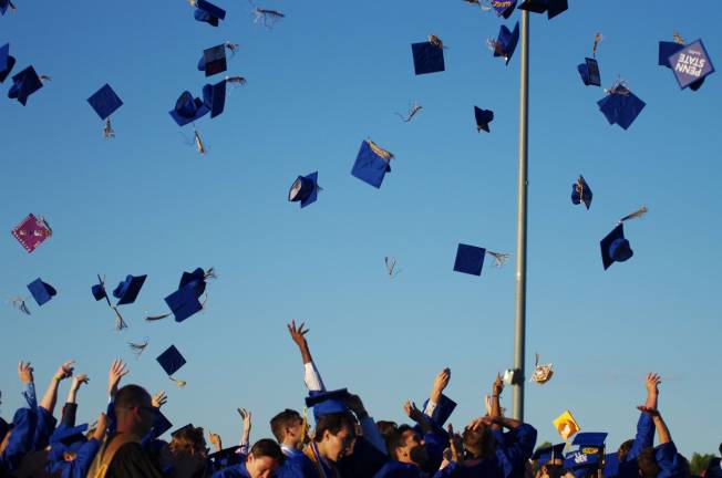 Graduates perform the traditional cap toss at the end of the graduation ceremony.