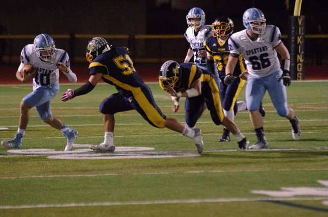 Sparta quarterback Anthony Argula (10) runs from Vernon linebacker Nicholas Rapisardi (51).