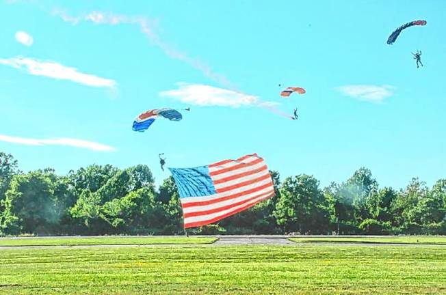 New Jersey Airshow AIR1 A skydiver from New York Tandem Sky Diving performs the ‘Flag Jump’ while holding the American flag alongside another skydiver at the New Jersey Airshow in West Milford. (Photo by Ed Bailey)