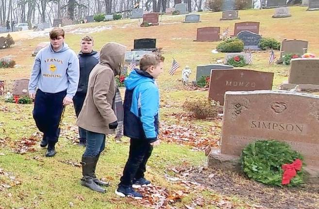 Two members of the community lay a wreath and thank the veteran for his service.