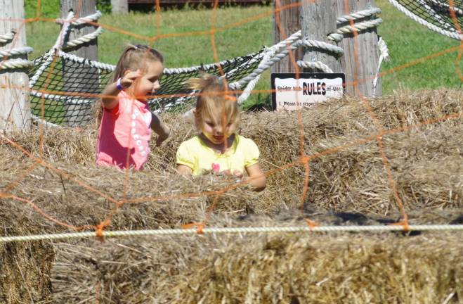 Two young girls explore the hay maze.