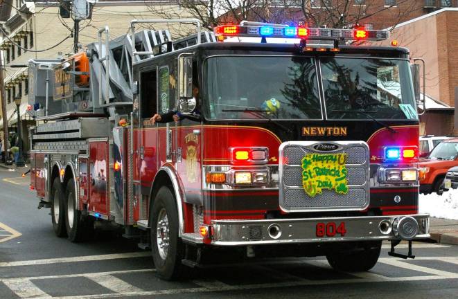 A Newton Fire Dept. truck rolls down the street during the St. Patrick's Day parade.