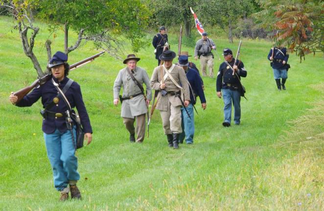 Both Union and Confederate troops march back to the encampment below.