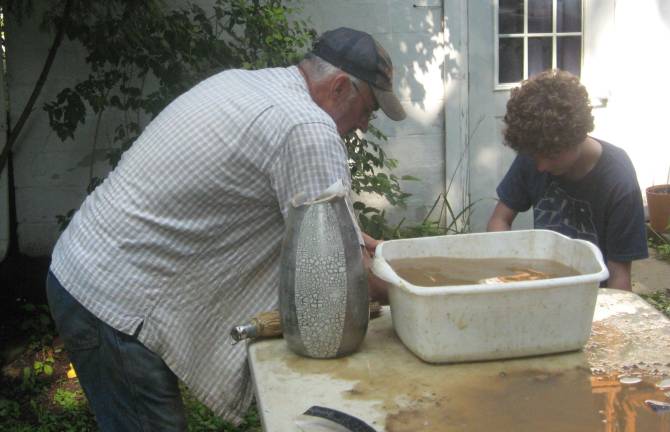 Archaeologist Geoffrey Purcell guides campers with their finds.