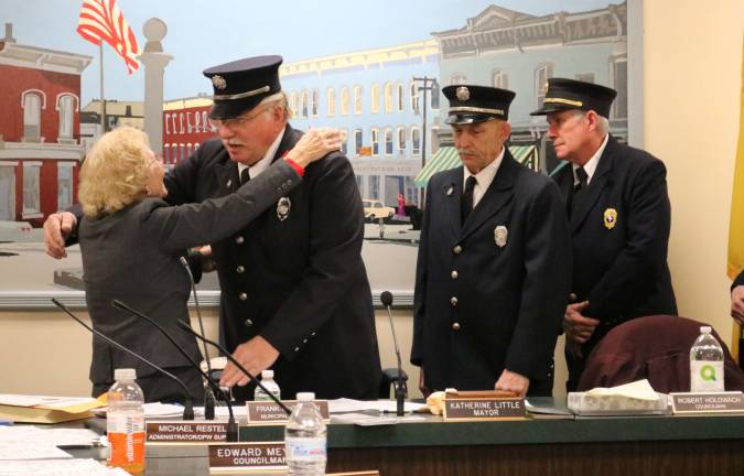 Forty-five year Sussex fire department veteran Stephen Funnell embraces Mayor Little after being officially sworn in for another year.