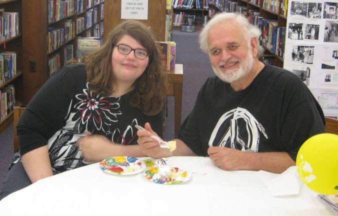 Father&#xfe;&#xc4;&#xec;daughter patrons Teagan and Steve Murdock of Hamburg enjoy cake at the library.