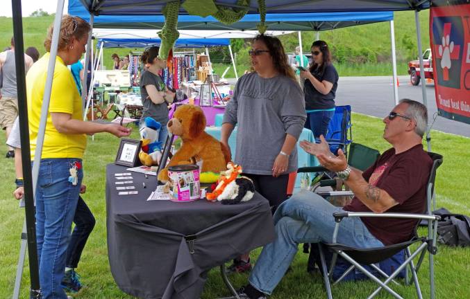 Vernon-based &quot;The Pet Emergency Card&quot; was one of the organizations on hand. Shown is Judi Maniscalco (center) and her husband Mike explained that the cards are to be kept with a driver&#xfe;&#xc4;&#xf4;s wallet so that in case of an accident or other emergency, police will know how to ensure your pets' welfare. See more at Facebook.com/ThePetEmergencyCard.