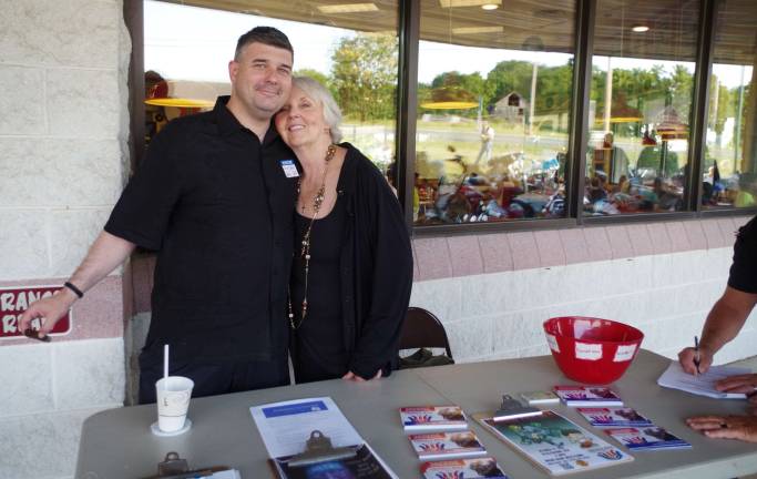 With cigar in hand, Shawn Enright of Catholic Family and Community Services joined Sandra Mitchell at her Project Help table.
