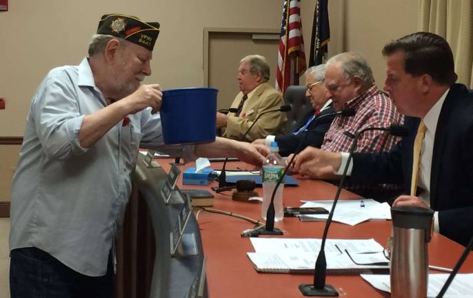 VFW past commander Russ Thomas distributing Buddy Poppies to council members.