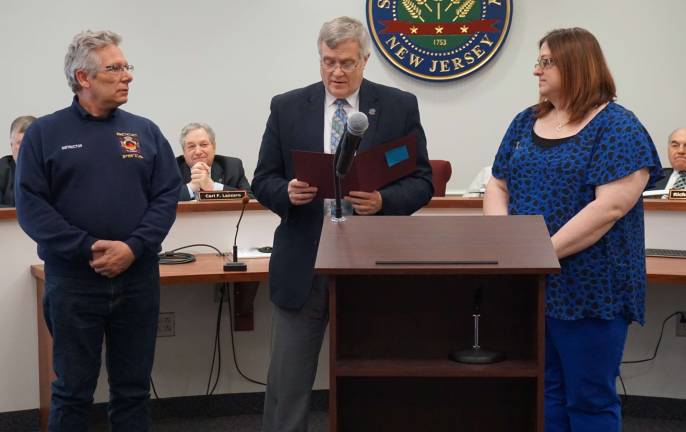 Freeholder Director George Graham, center, reads the proclamation designating April as Autismm Awareness month. Larry Bono is shown at left and Renee Riley is at right.