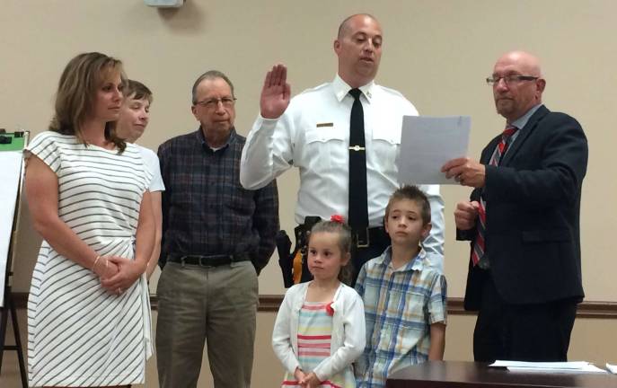 Capt. Dan Young, stands with his family and Mayor Harry Shortway, while taking an oath of service upon his promotion from Lieutenant to Captain in the Vernon Police Department.