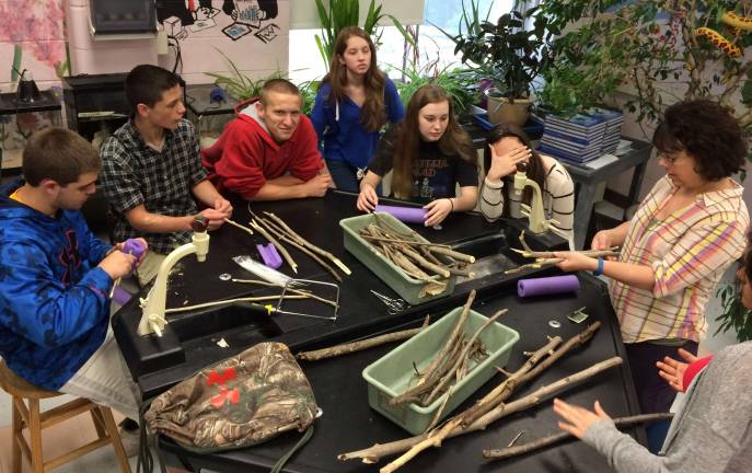 Mrs. Frey, VTHS biology teacher, shows her &#xfe;&#xc4;&#xfa;tribe&#xfe;&#xc4;&#xf9; the craft of raft making. The completed rafts were &#xfe;&#xc4;&#xfa;drifted&#xfe;&#xc4;&#xf9; down a local stream as the culminating contest in the Huckleberry Finn Exploration Project.