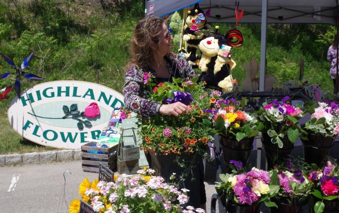 Lori Struck of Highland Flowers does a little botanical arranging with the help of her stuffed bumblebee.