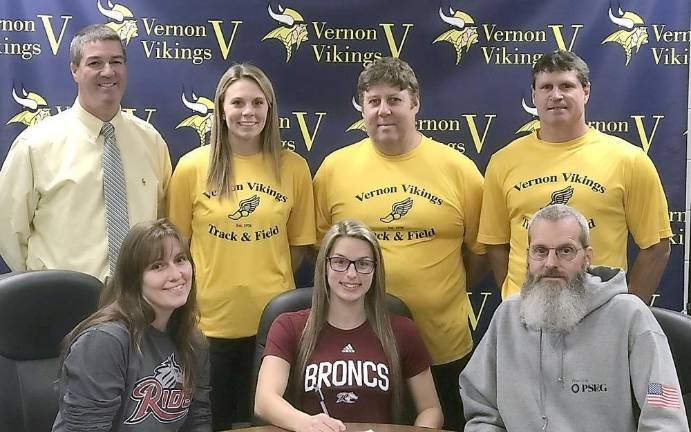 Seated, from left: Mrs. Wilkens, Jessica Wilkens and Mr. Wilkens. Standing left to right: AD Bill Foley, Assistant Coach Stephanie DePiano, Head Coach Jim Saganiec and Assistant Coach Brian McCarthy.