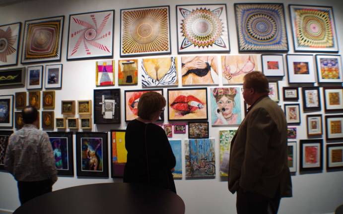 Visitors are shown during the Art Etc Gallery&#xfe;&#xc4;&#xf4;s holiday gathering. In the background are a series of paintings created by Sparta artist Patty Margalotti meant to raise awareness of breast cancer. Margalotti is striving to establish herself in the art world. Her influences include the great Edward Degas and Claude Monet.