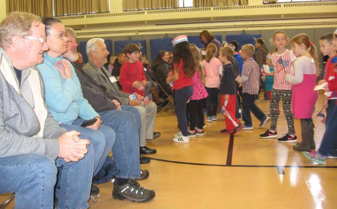 PHOTOS BY JANET REDYKECedar Mountain students give special red, white and blue gifts to veterans attending the Veterans Day program at the school.