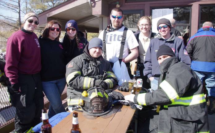 Members of the Vernon Fire Department&#xfe;&#xc4;&#xf4;s race team and members of their ladies auxiliary relax on a deck in front of Kite at the 28th annual New Jersey Firefighters Ski Race held Friday at the Mountain Creek Ski Resort in Vernon.
