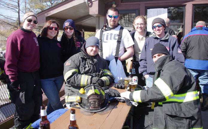 Firefighters race for burn center Members of the Vernon Fire DepartmentþÄôs race team and members of their ladies auxiliary relax on a deck in front of Kite at the 28th annual New Jersey Firefighters Ski Race held Friday at the Mountain Creek Ski Resort in Vernon.