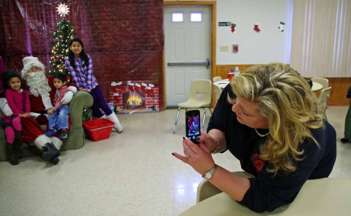 Using visitors&#xfe;&#xc4;&#xf4; cell phones and a variety of their other cameras to take family photos was Michele Clark, a member of the Ladies Auxiliary.