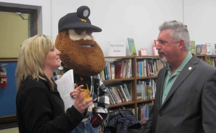 Sussex County Miners Adrienne Sprung, and Mascot, Herbie, speaking with Sussex-Wantage Regional School District Board of Education President Robert Heiden during Read Across America Day.