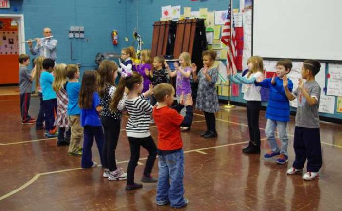The kids put on a dance routine for the visiting veterans with their music teacher Michael Moschella playing &quot;Yankee Doodle Dandy&quot; on the flute.