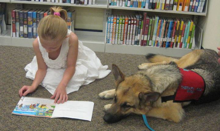 Therapy dog visits library Abigail Hanson expressively reads about Scooby Doo.