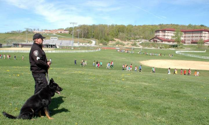 Being prepared Sgt. Dave Campbell of the Orange County Sheriff's Department and Scout, an explosive detector K-9, watch as students evacuate Central Valley Elementary as part of a planned drill in May 2013.