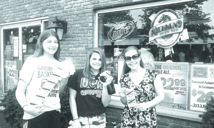 Pictured with a supply of stickers is Ayla Satter, Community Educator of CFPC, and the CTI youth group in action at Burke&#x2019;s. Cpl. Sue Parkes of the Sparta Police Department and Tina Thompson, CTI Coordinator from the Center for Prevention and Counseling, also joined in this event.