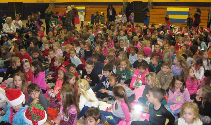 The excited mass of primary graders wait for the concert&#x2019;s start.