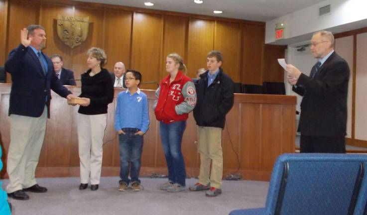 Commiteeman Jon Morris is sworn in by Township Administrator James Doherty as his family looks on.